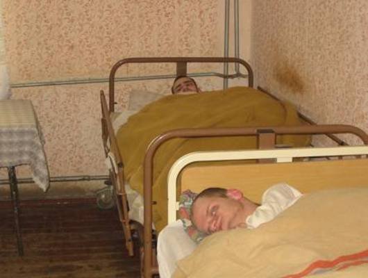 Photo: Liegende Patienten. Man sieht, die Räume sind sehr schmutzig und müssen dringend erneuert werden.