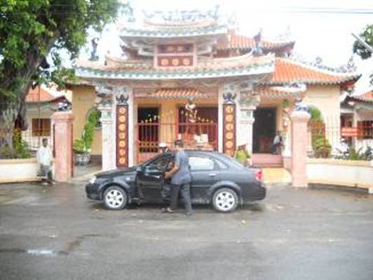 Photo 1: Hier ist der Eingang der Tempel Helfstation in Rach Gia und unser Fahrer mit dem Auto vom Herrn Hieu.