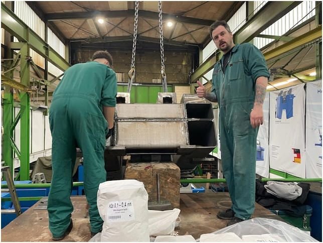 WIAP Umbau Safop CNC-Drehmaschine: Bild 3: Jim Widmer und Kim, unser Enkel, beim Befüllen des Betts. 5 Tonnen Material werden