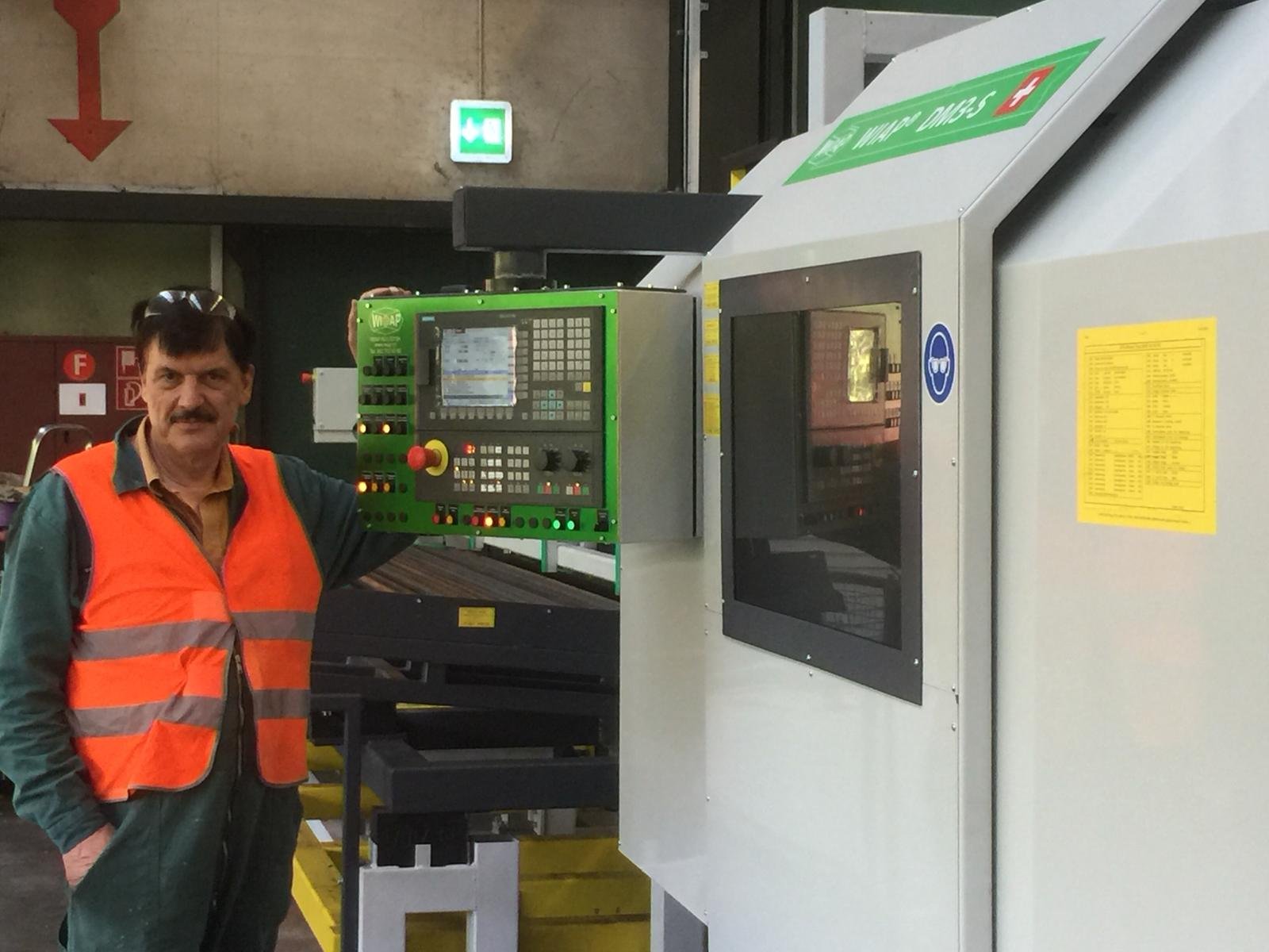 Bild 1: HP Widmer neben der CNC Rollier- und Schälmaschine WIAP DM3S.